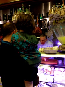 A child and her dad watch as their order is being prepared. 